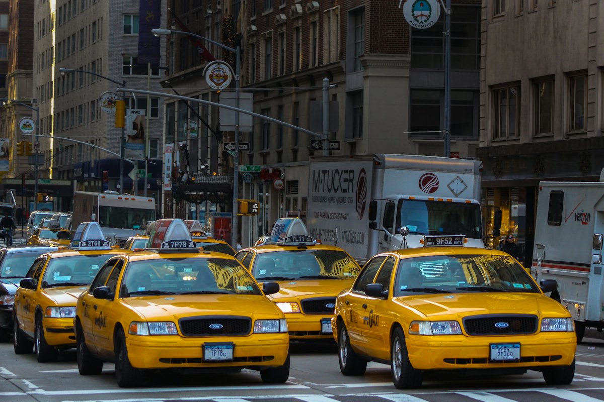 Defensa liquidación venta licencia taxi Valencia: taxi circulando junto a un edificio