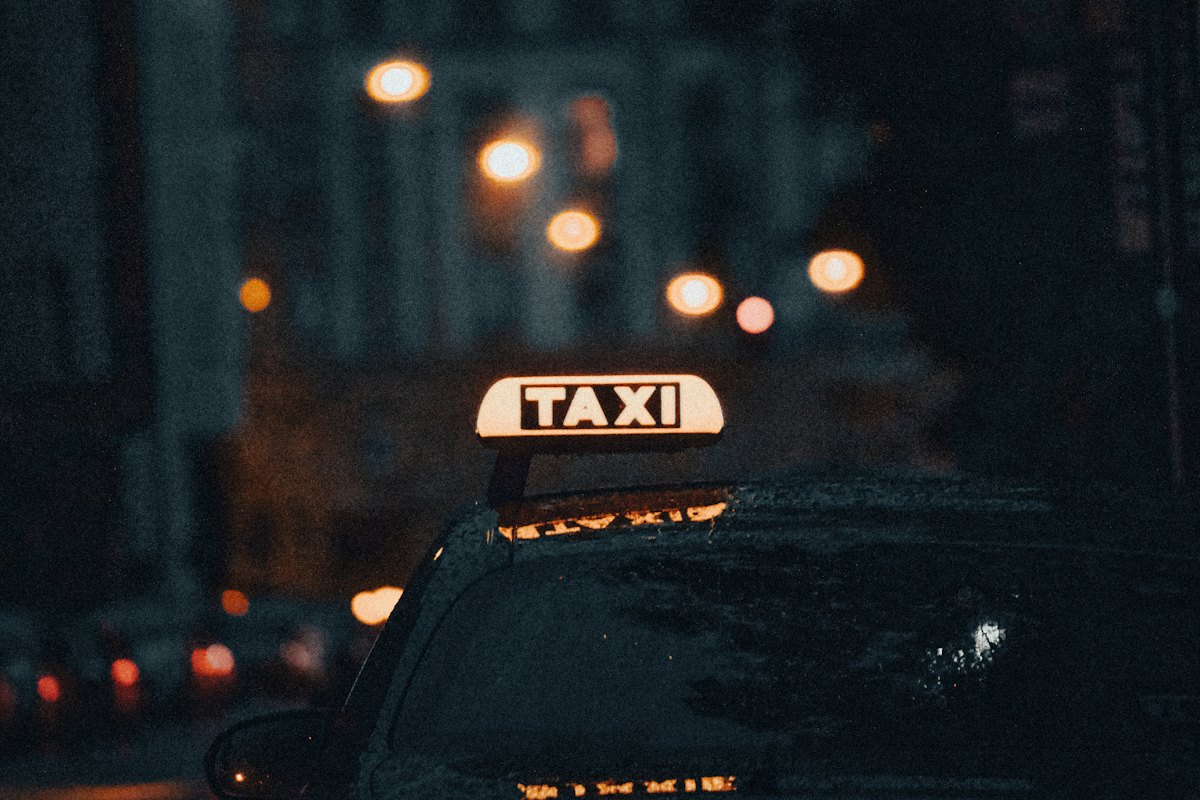 Transmisión licencia VTC IVA o sin IVA Madrid: vehículo con conductor en una vía urbana